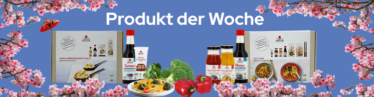 Asiatische Bio-Wok-Produkte mit Frühlingsblüten und Gemüse vor blauem Hintergrund